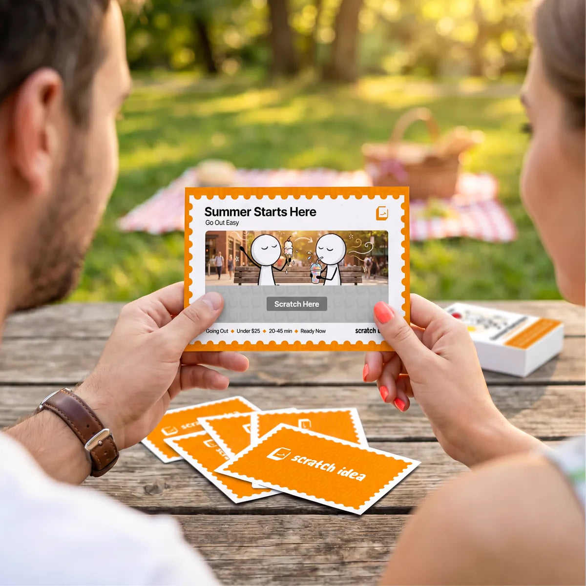 A couple outdoors reading a Summer Starts Here card